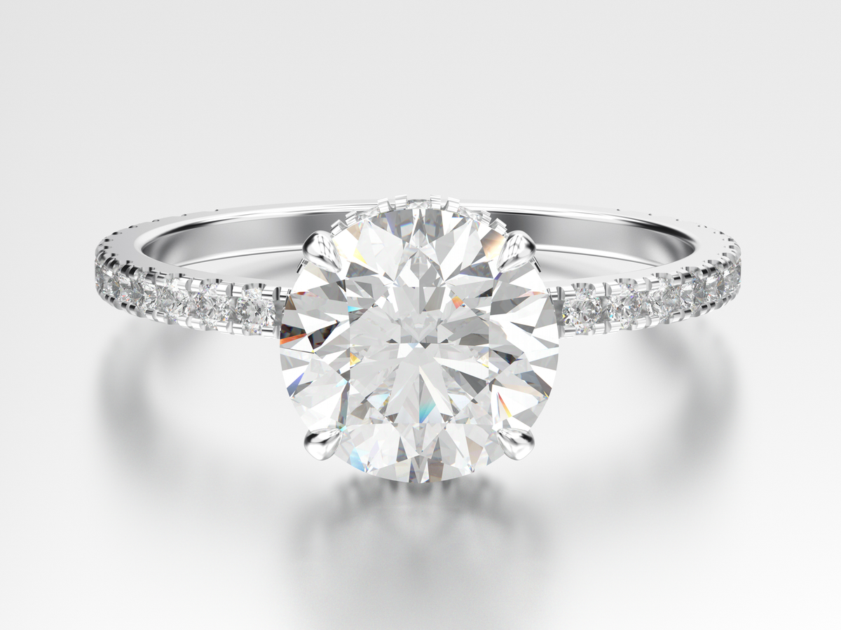 Close up of a round diamond engagement ring with round diamonds prong set on the band