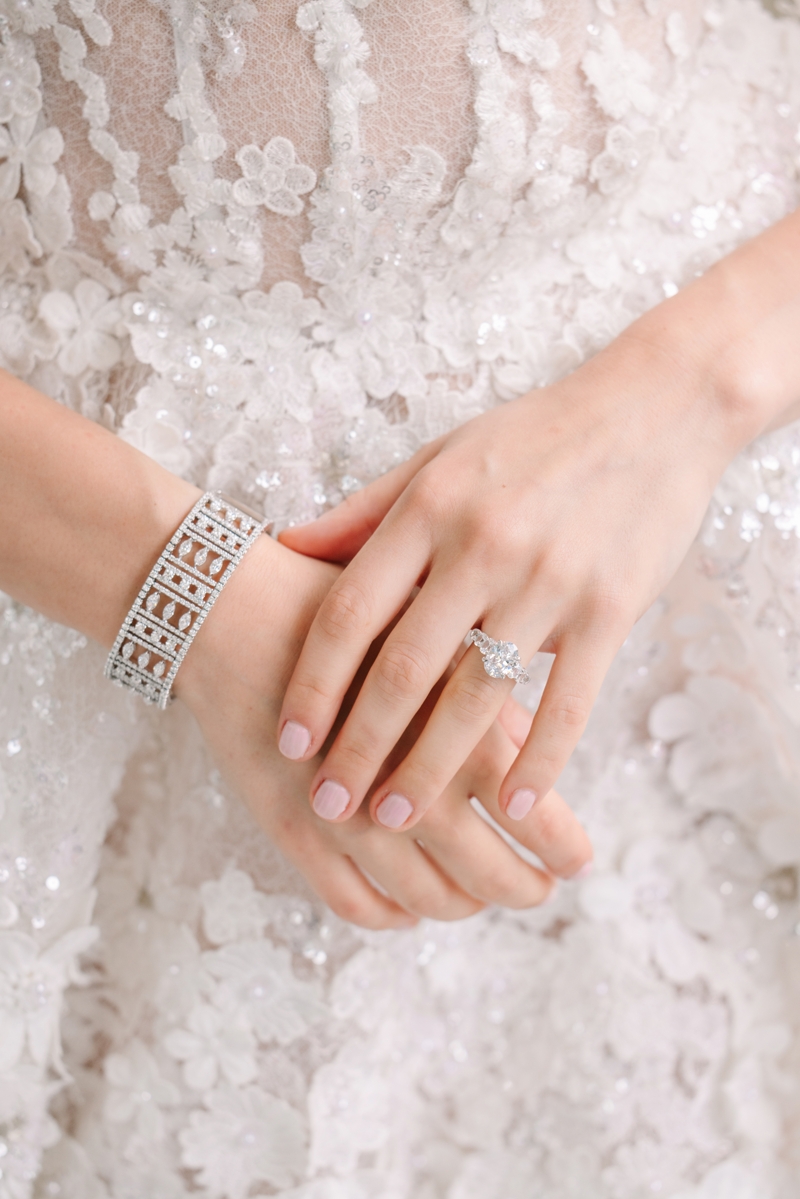 Close up of hands with an engagement ring and diamond bracelet on