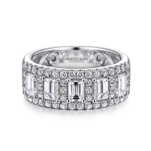 Wide white gold anniversary band with emerald cut diamonds surrounded by pave set round diamonds