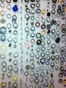Many wax models of custom rings mounted on a wall