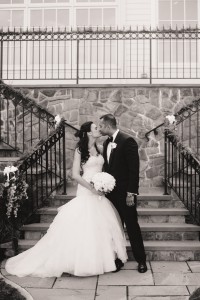 A black and white photo of Alyssa and Rohan kissing on their wedding day