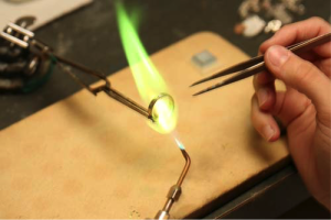 Close up of a jeweler welding a ring